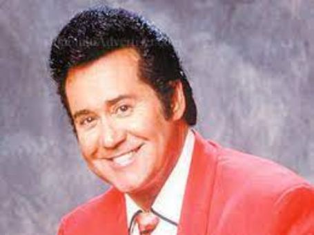 An old picture of Wayne newton in which he is seen smiling.